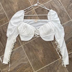 White top with puffy sleeves and lace up detail.